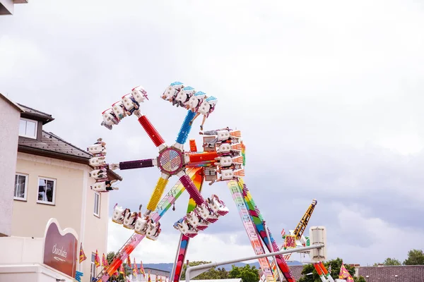 Villach, Avusturya - 30 Temmuz 2025: Villacher Kirchtag festivalinde renkli dönme dolap, neşeli atmosferi güçlendiren şenlikli süslemelerle bulutlu bir gökyüzüne karşı kurulmuştur