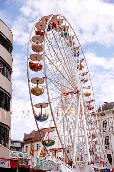 Villach, Avusturya - 30 Temmuz 2025 Villacher Kirchtag festivalinde canlı bir dönme dolap, renkli gondollar ve şenlikli bayraklarla süslenmiş, canlı bir sahne yaratıyor.