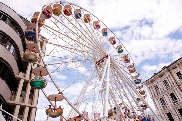 Avusturya 'nın Villach kenti - 30 Temmuz 2025: Vibrant dönme dolap Avusturya' daki Villacher Kirchtag festivalinde renkli gondollar ve fotokopi alanı ile çarpıcı bir gökyüzü arkaplanı