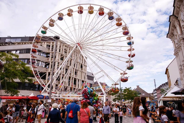 Villach, Avusturya - 30 Temmuz 2025: Villacher Kirchtag festivalinde kalabalığın atmosferin ve Villach 'ta renkli balonların tadını çıkardığı canlı bir dönme dolap sergileniyor