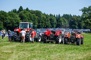 Ossiacher Tauern, Avusturya - 10 Ağustos 2025: Rindfleischfest renkli traktörleri yeşil bir alanda sergiliyor