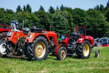 Ossiacher Tauern, Avusturya - 10 Ağustos 2025: Vintage traktörler Rindfleischfest 'teki yemyeşil çimlerde sergileniyor, tarımsal gelenekleri ve toplumsal bağlılığı kutluyorlar
