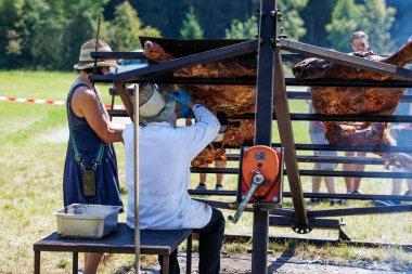 Ossiacher Tauern, Avusturya - 10 Ağustos 2025: Rindfleischfest etkinliği, canlı festival atmosferiyle şefin açık havada ızgara yapması ve seyircilerin manzaranın keyfini çıkarması