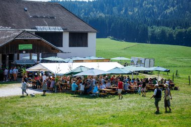 Ossiacher Tauern, Avusturya - 10 Ağustos 2025: Rindfleischfest etkinliği, manzaralı kırsal bir ortamda çadırların altında büyük bir kalabalığın yemek yediği bir etkinlik