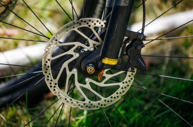 Ossiacher Tauern, Avusturya - 10 Ağustos 2025: Bisiklet disk freninin yakın çekimi, güvenlik ve performans alanındaki rolünü gösteren ayrıntılı tasarım ve metalik kaplamayı vurguluyor