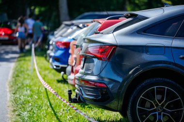 Ossiacher Tauern, Avusturya - 10 Ağustos 2025: Rindfleischfest manzaralı bir yol boyunca park etmiş renkli bir dizi arabaya yer veriyor