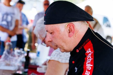 Ossiacher Tauern, Avusturya - 10 Ağustos 2025: Rindfleischfest 'te şef canlı bir açık hava ortamında lezzetli et yemekleri pişirmeye adanmıştır.