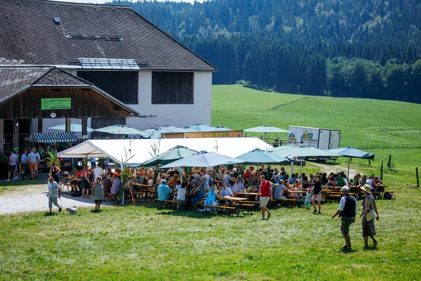 Ossiacher Tauern, Avusturya - 10 Ağustos 2025: Rindfleischfest etkinliği, manzaralı kırsal bir ortamda çadırların altında büyük bir kalabalığın yemek yediği bir etkinlik