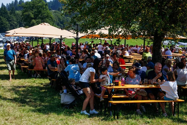 Ossiacher Tauern, Avusturya - 10 Ağustos 2025: Rindfleischfest, şemsiyeler altında yemek ve içeceklerden keyif alan neşeli bir kalabalığa ev sahipliği yapıyor.