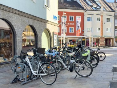 Lienz, Avusturya - 18 Eylül 2025: Bisikletler renkli dükkanlar ve binalarla çevrili canlı bir kasaba meydanına park edilmiş, kentsel kültür ve toplum yansıtılıyor