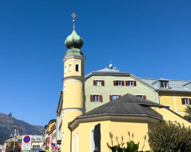 Lienz, Avusturya - 18 Eylül 2025: Renkli mimari, güneşli bir dağ kasabasında yerel tasarımın güzelliğini vurgulayan yeşil bir kubbe ve saat kulesine sahiptir.