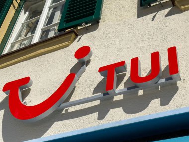 Lienz, Avusturya - 18 Eylül 2025: TUI logosu, canlı kırmızı rengini ve seyahat ve turizm bağlantısını vurgulayarak, binanın ön cephesinde sergileniyor