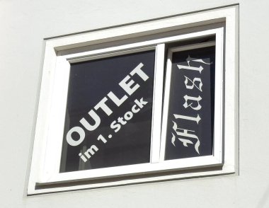 Lienz, Avusturya - 18 Eylül 2025: Şehir perakende atmosferini vurgulayan cesur yazı ve sanat tasarımı ile mağaza vitrinleri