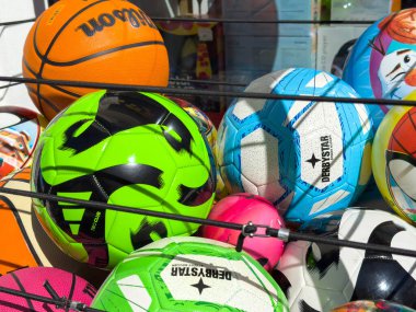 Lienz, Avusturya - 18 Eylül 2025: Futbol, basketbol ve voleybol da dahil olmak üzere çeşitli spor topları canlı bir perakende satış ortamında sergilendi