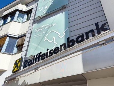 Lienz, Avusturya - 18 Eylül 2025: Raiffeisenbank dış görünümü hareketli bir şehir ortamında çağdaş tasarım ve markalaşmayı vurguluyor