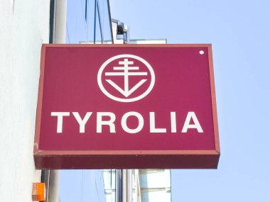 Lienz, Avusturya - 18 Eylül 2025: Tyrolia marka tabelası açık bir gökyüzüne karşı logo ve parlak renklerle gösteriliyor, kentsel atmosferi vurguluyor