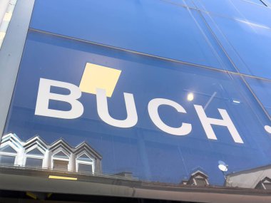 Lienz, Avusturya - 18 Eylül 2025: Buch mağaza tabelası, kentsel mimari ve şehir atmosferini yansıtan cam cephe karşısında modern tipografiyi gösteriyor