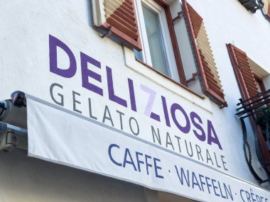 Lienz, Avusturya - 18 Eylül 2025: Panjurlu antika bir binada Deliziosa gelato naturale tabelası, ziyaretçileri lezzetli dondurma ve tatlıların tadını çıkarmaya davet ediyor