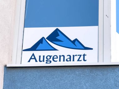 Lienz, Avusturya - 18 Eylül 2025: Göz bakımı kliniğinde mavi dağ logosu ve Augenarzt metni sergilenerek, görüş bakımı için elverişli bir ortam yaratıldı