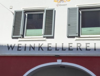 Lienz, Avusturya - 18 Eylül 2025: Weinkellerei tabelası yeşil panjurlu bir binada belirgin bir şekilde sergilendi, kentin mimari güzelliğini vurguladı