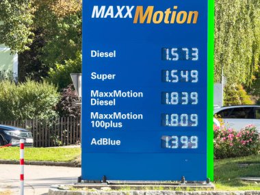 Lienz, Avusturya - 18 Eylül 2025: MAXXMotion benzin istasyonu fiyat tabelası, yemyeşil ve açık gökyüzünün ortasında dizel, süper ve AdBlue fiyatlarını gösteriyor