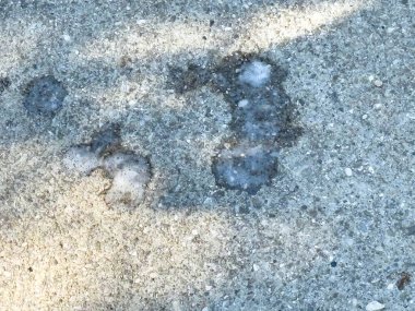 Soyut lekeli beton yüzey gölgeler ve dokularla kaplı..