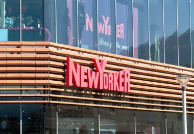Wolfsberg, Avusturya - 19 Eylül 2025: New Yorker mağazasının ön yüzünde modern perakende estetiği ve kentsel canlılığı vurgulayan kırmızı logo ve parlak cam tasarımı yer alıyor