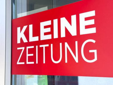 Wolfsberg, Avusturya - 19 Eylül 2025: Parlak kırmızı tabela, yerel bir gazete olan Kleine Zeitung 'u içeriyor.