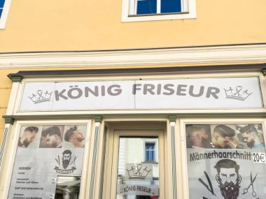 Wolfsberg, Avusturya - 19 Eylül 2025: Konig Friseur berber dükkanı modern tımar hizmetlerini ön plana çıkaran ve atmosferi davet eden şık saç kesimlerine sahiptir.