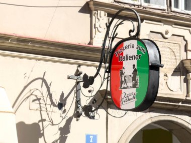 Wolfsberg, Avusturya - 19 Eylül 2025: Pizzacı Zum Italiener tabelası İtalyan bayrağının renklerini gösteriyor, tarihi bir bölgedeki bu büyüleyici restoranın davetkar atmosferini artırıyor