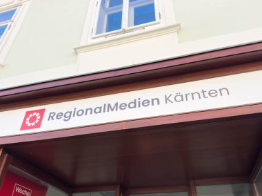 Wolfsberg, Avusturya - 19 Eylül 2025: Bölgesel Medien Karnten tabelası mağaza vitrininde belirgin bir şekilde gösterilmiş, canlı kentsel bir çevrede markalaşmayı vurguluyor