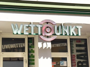 Wolfsberg, Avusturya - 19 Eylül 2025: Wettpunkt tabelaları belirgin bir şekilde sergilenmiş, canlı şehir ortamında parlak renklerle bir spor bahis dükkanı olduğunu gösteriyor