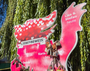 Wolfsberg, Avusturya - 19 Eylül 2025: Renkli aşk kilidi parkta, çiftler arasındaki sevgi ve bağlılığı sembolize eden kalp şeklinde bir işaret sunar