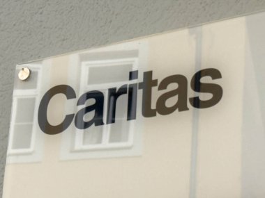 Wolfsberg, Avusturya - 19 Eylül 2025: Caritas şehir mimarisi ve topluma odaklı destek ve yardım misyonu sergilenen dış duvarda imza attı