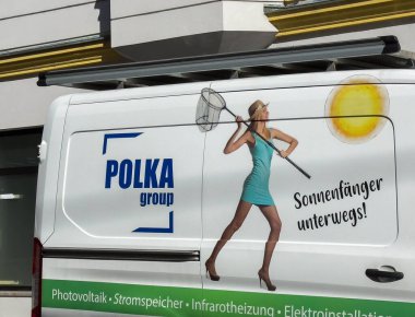 Wolfsberg, Avusturya - 19 Eylül 2025: Polka Grubu aracı, eşsiz pazarlama ve markalaşma stratejisini vurgulayarak, net, parlak güneşli mavi elbiseli bir kadını sergiliyor