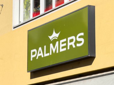 Wolfsberg, Avusturya - 19 Eylül 2025: Palmers logosu, kentsel estetik ve marka görünürlüğünü artıran sarı bir duvarda yer almaktadır