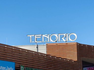 Wolfsberg, Avusturya - 19 Eylül 2025: Tenorio marka tabelası ahşap elementler ve parlak mavi gökyüzü ile şık bir bina cephesinde sergilenmektedir