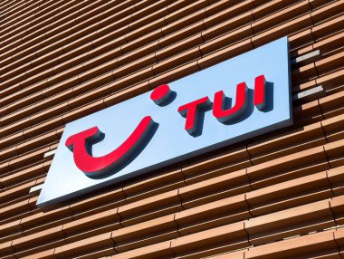 Wolfsberg, Avusturya - 19 Eylül 2025: TUI logosu, kentsel bir ortamda modern tasarım ve markalaşmayı ön plana çıkaran, şık bir ahşap duvarda yer almaktadır.