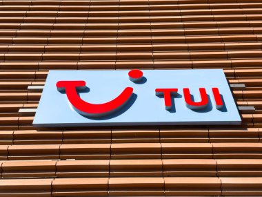 Wolfsberg, Avusturya - 19 Eylül 2025: TUI logosu, modern tasarım ve markalaşma unsurlarını vurgulayan ahşap panellerle bir binanın ön cephesinde sergilenmektedir