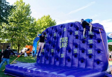 Villach, Avusturya - 20 Eylül 2025: Genç tırmanışçılar canlı bir atmosferde eğlence ve rekabeti ön plana çıkaran CRUX GÜF etkinliğinde şişme duvarla meşgul oluyorlar