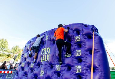 Villach, Avusturya - 20 Eylül 2025: Sporcular CRUX 'taki etkinlikte şişme duvara tırmanıyorlar, canlı bir atmosferde güç ve dostluk gösteriyorlar