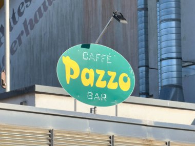 Bleiburg, Avusturya - 19 Eylül 2025: Caffe Pazzo bar tabelası parlak renkler ve kahve meraklıları için davetiye tasarımı içeren binada belirgin bir şekilde sergilenmektedir