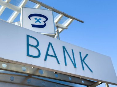 Bleiburg, Avusturya - 19 Eylül 2025: Açık işaret ve parlak mavi gökyüzü ile çağdaş bir banka binasının dış görünümü