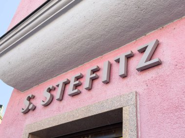 Bleiburg, Avusturya - 19 Eylül 2025: S. Stefitz tabelaları parlak pembe bir duvarda sergilenmiş, bölgenin eşsiz tasarımı ve kentsel karakterini vurguluyor.