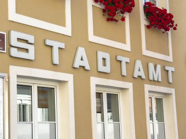 Bleiburg, Avusturya - 19 Eylül 2025: Stadtamt binası, ziyaretçiler için davetkar bir kentsel atmosfer yaratan, kırmızı çiçekli modern mimariye sahiptir.