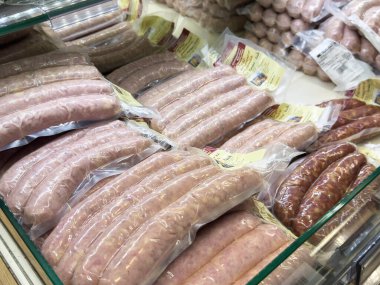 Bleiburg, Avusturya - 19 Eylül 2025: Bir kasapta paketlenmiş sosisler, farklı et ürünleri çeşitlerini ve dokularını vurgulayarak düzgünce düzenlenir