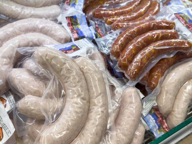 Bleiburg, Avusturya - 19 Eylül 2025: Açık ambalajda çeşitli sosisler, et ürünlerinin farklı dokularını ve renklerini vurgulayarak bir pazarda düzenlenmektedir