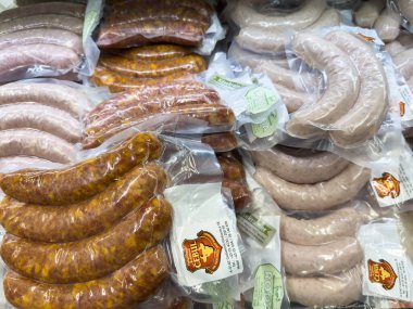 Bleiburg, Avusturya - 19 Eylül 2025: Açık ambalajda çeşitli sosisler, farklı lezzet ve dokuları ön plana çıkaran bir pazar rafında düzgün bir şekilde düzenlenmiştir