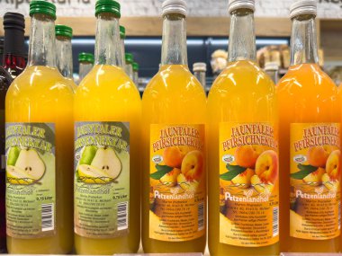 Bleiburg, Avusturya - 19 Eylül 2025: Jauntaler Pfirsichnektar meyve suyu şişeleri bir market rafında sergileniyor, parlak renkleri ve çekici tasarımı vurgulanıyor