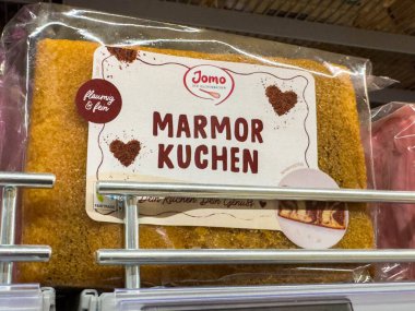 Bleiburg, Avusturya - 19 Eylül 2025: Açık ambalajlı Jomo mermer pasta zengin dokular ve davetkar tasarım sergiliyor, tatlı severler ve fırın meraklıları için ideal.